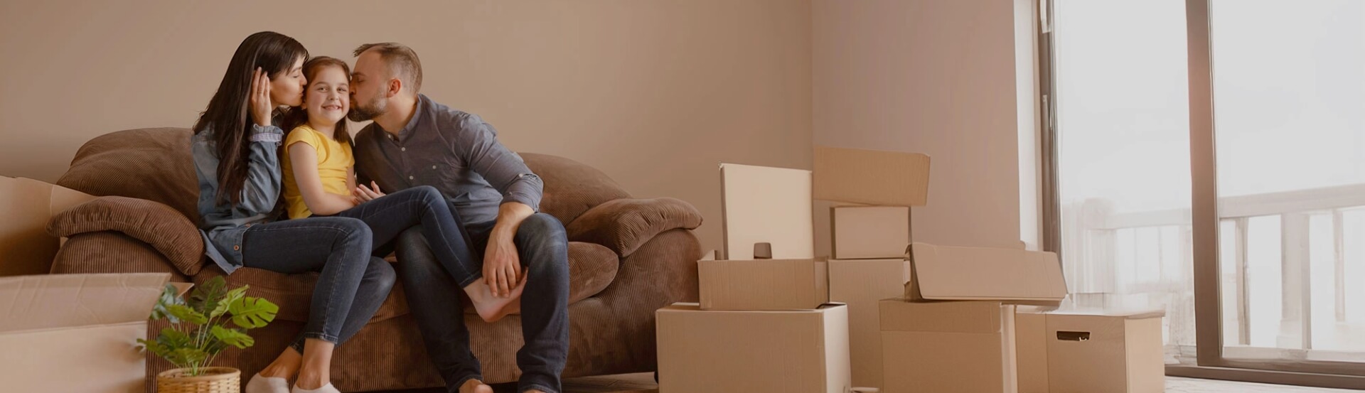 Familia en su nueva vivienda junto a cajas de mudanza